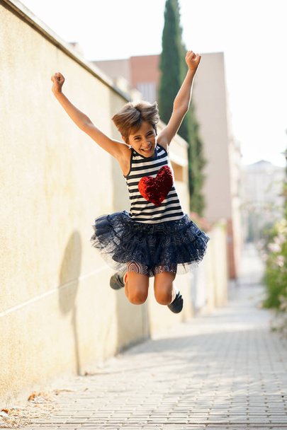 Маленька дівчинка, вісім років, стрибає на відкритому повітрі
. - Фото, зображення