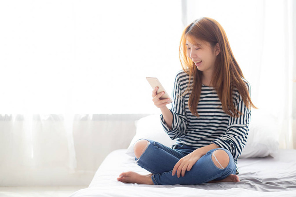 Belle jeune femme asiatique souriant assis se détendre sur le lit en
  - Photo, image