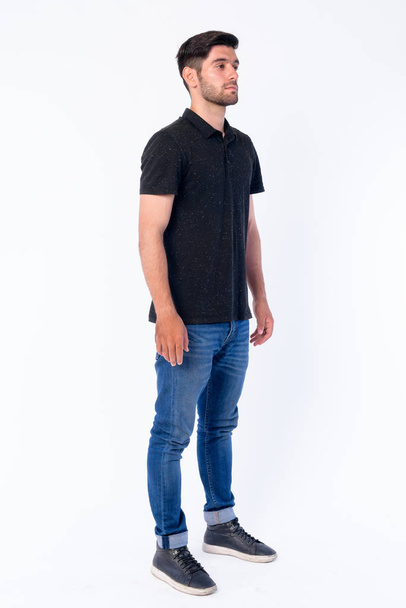 Full body shot of young bearded Persian man thinking - Foto, afbeelding