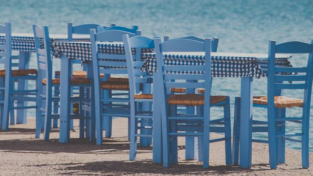 Open cafe outdoor restaurant in Greece on sea shore - Fotoğraf, Görsel