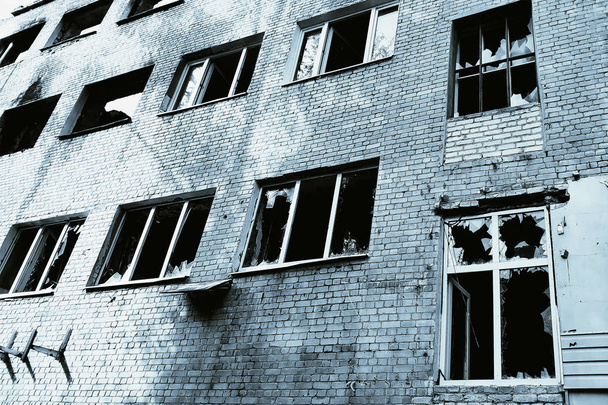 Casa com janelas quebradas e paredes danificadas. Conceito- guerra, devastação, desastres, emergências
. - Foto, Imagem