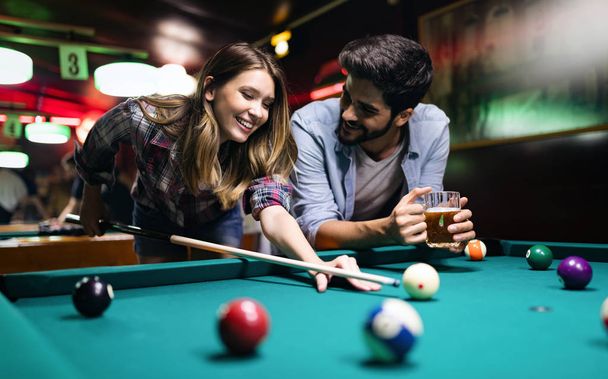 Couple dating, flirting and playing billiard in a pool hall - Foto, Bild