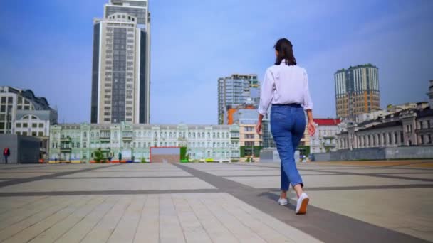 back view rento nainen kävelee moderni kaupunki kesäkaudella
 - Materiaali, video