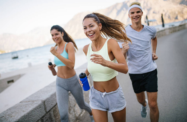 Happy friends fitness training together outdoors living active healthy - Valokuva, kuva
