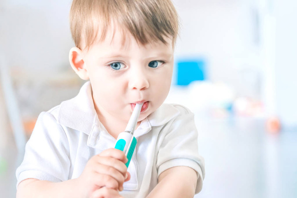 Lovely blue eyed blond babe brushing his teeth with a toothbrush - Φωτογραφία, εικόνα
