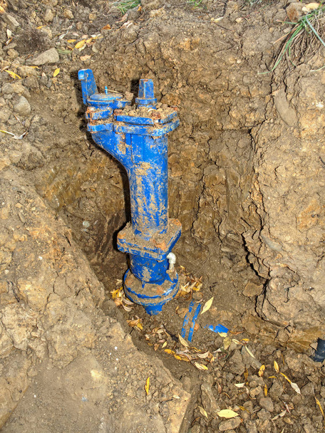 Reparatur des Wasserversorgungssystems. Graben mit Rohren unter Haus - Foto, Bild