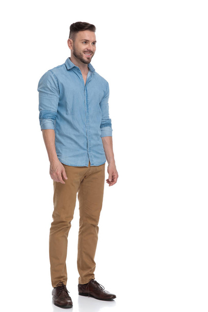 casual man standing and looking ahead happy in side view - Photo, Image