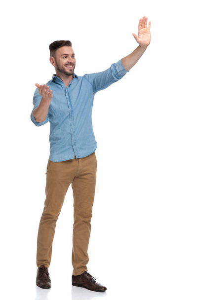 Casual man saluting met een hoe ben je ondertekenen - Foto, afbeelding
