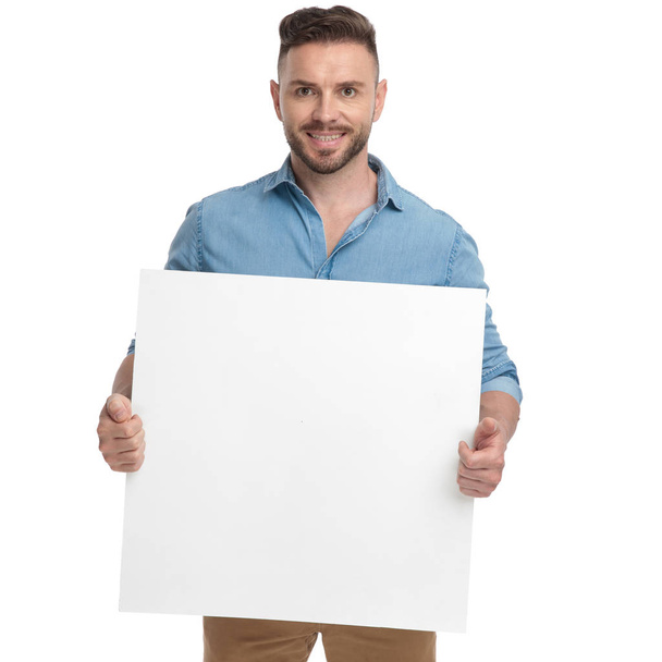 casual man standing with billboard on hands happy - Фото, зображення