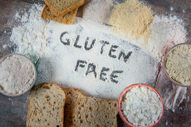 gluteeniton leipä ja jauhot puupohjalla
 - Valokuva, kuva