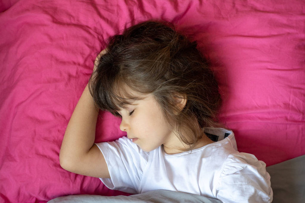 Kid sleep alone in her own bed. 5 or 6 years old kid sleep at home, bedroom.  - 写真・画像