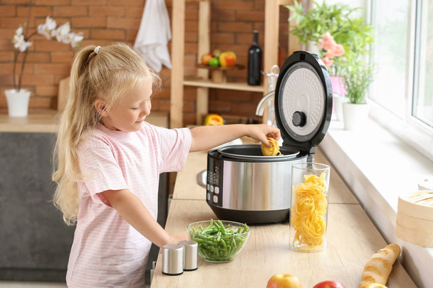 Little girl using modern multi cooker in kitchen - Фото, зображення
