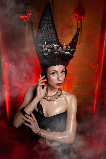 Evil stylish woman witch with big black hat on dark scary smoky background alone - Photo, Image