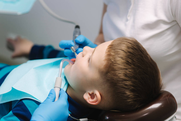 Zbliżenie młodego chłopca siedzącego na fotelu dentystycznym w biurze. Dzieci dentysta badanie zębów dla dzieci - Zdjęcie, obraz
