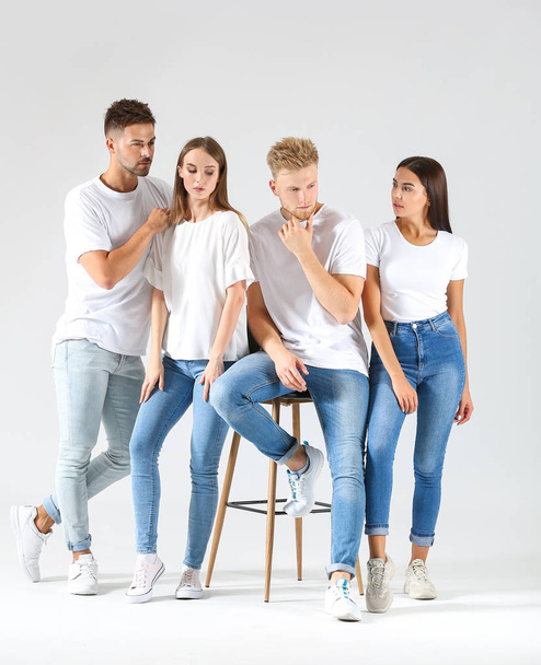 Gruppe junger Leute in stylischer Freizeitkleidung auf hellem Hintergrund - Foto, Bild