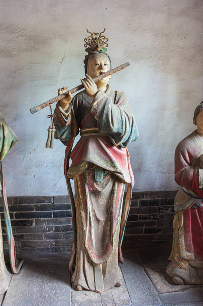 Huilu soittaa palvelijattaria Jincin temppelissä Taiyuanissa
 - Valokuva, kuva