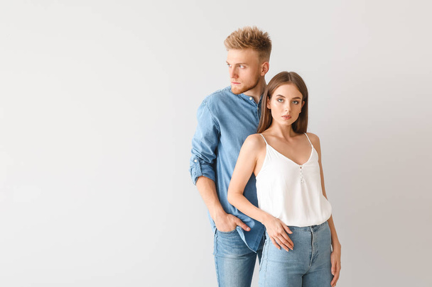 Young couple in stylish casual clothes on light background - Photo, Image