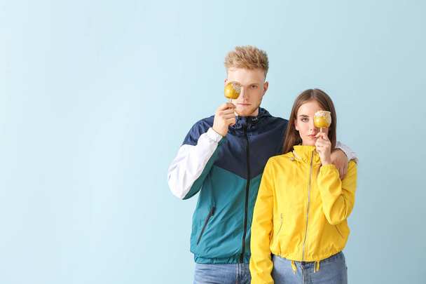 Молода пара в стильному спортивному одязі на кольоровому фоні
 - Фото, зображення