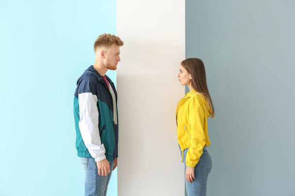 Молодая пара в стильной спортивной одежде на цветном фоне
 - Фото, изображение