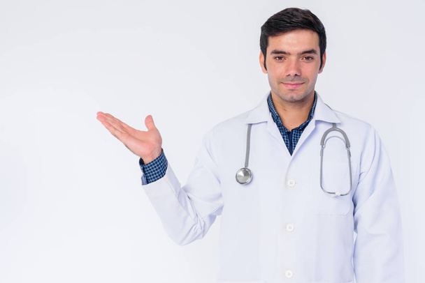Portrait of young Persian man doctor showing something - Foto, Imagen