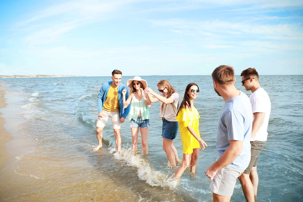 Amigos felizes se divertindo na praia do mar no resort
 - Foto, Imagem