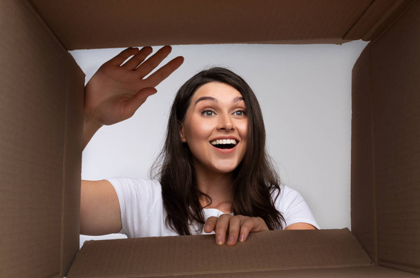 Izgatott lány keres Inside üres doboz, alsó nézet - Fotó, kép