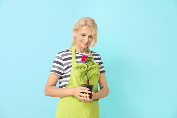 Portrait of female gardener on color background - Φωτογραφία, εικόνα