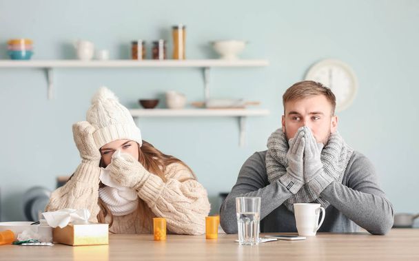 Sick couple sitting at kitchen table - Foto, afbeelding