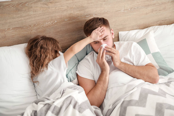 Niña cuidando a su padre enfermo de gripe en casa
 - Foto, Imagen