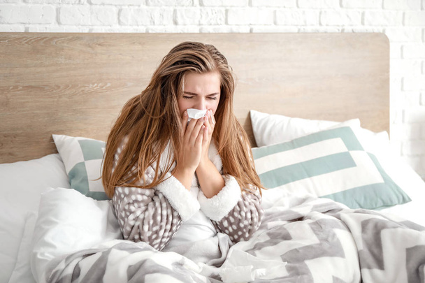Mujer enferma sentada en la cama en casa
 - Foto, imagen