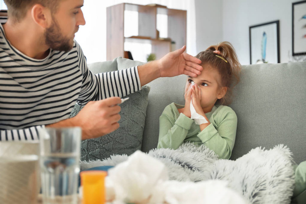 Father taking care of his daughter ill with flu at home - Valokuva, kuva