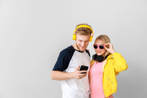 junges Paar hört Musik auf hellem Hintergrund - Foto, Bild