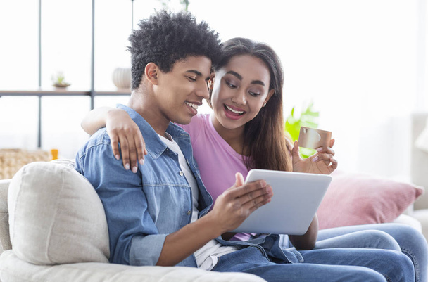 Teenager-Paar kauft online mit digitalem Tablet zu Hause ein - Foto, Bild