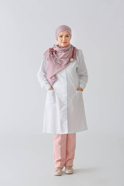 Beautiful mature Muslim doctor on light background - Φωτογραφία, εικόνα