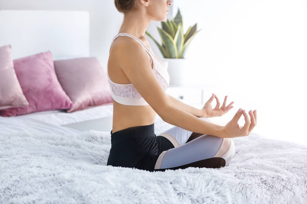 Jeune femme pratiquant le yoga dans la chambre
 - Photo, image
