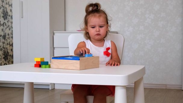 kislány, 2 éves, játszik oktatási játékok, halmok és rendezi színes számok. A tanulás tapasztalati koncepciók, durva, finom motoros készségek révén - Fotó, kép