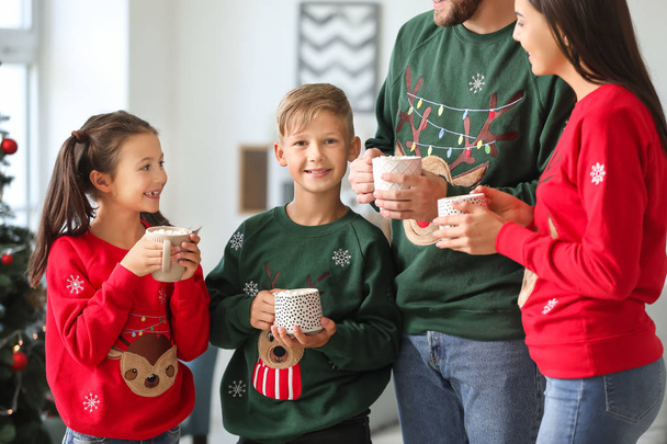 Onnellinen perhe juo kuumaa kaakaota kotona jouluaattona
 - Valokuva, kuva