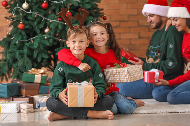 Gelukkige familie met cadeaus thuis op kerstavond - Foto, afbeelding