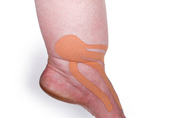 Ruban thérapeutique élastique de couleur chair collé sur le pied féminin
 - Photo, image