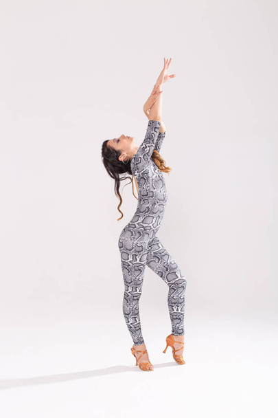 Латинский танец, стриптиз-танец, contemporary and fashion lady concept - женщина, танцующая импровизацию и двигающая длинными волосами на белом фоне
 - Фото, изображение