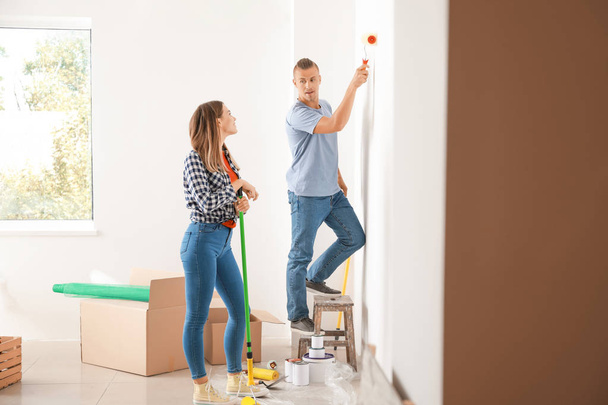 Happy young couple doing repair in their new house - Foto, Bild