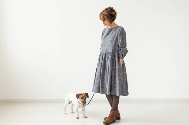 Concepto de propietario de moda y mascotas: mujer joven posando en ropa con Jack Russell en el estudio sobre fondo blanco
 - Foto, imagen