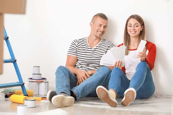 Happy young couple choosing color of walls in their new house - Foto, immagini