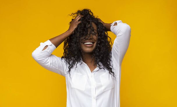 Сексуальная черная девушка, улыбающаяся с закрытыми глазами, трогающая волосы
 - Фото, изображение