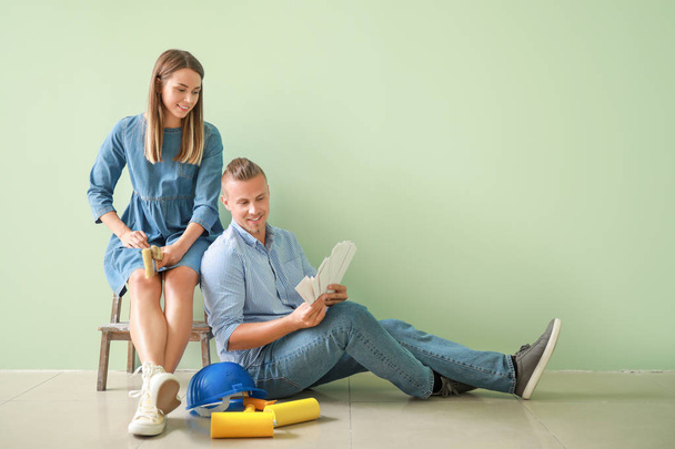 Happy young couple choosing color of walls in their new house - Фото, зображення