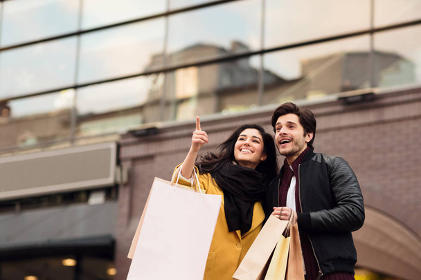 ミレニアル幸せなカップルは、新しい都市で一緒に買い物をし、歩く - 写真・画像