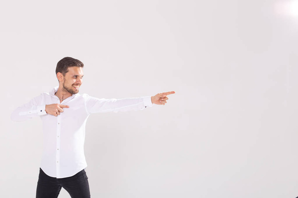 bel homme avec barbe pointant dans une direction sur un fond blanc, copyspace
 - Photo, image