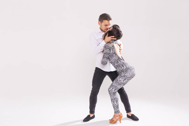 Passionate couple dancing social danse kizomba or bachata or semba or taraxia on white background with copy space - Photo, Image