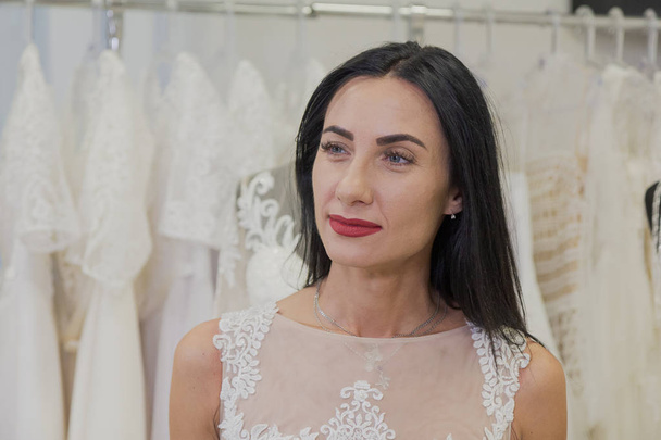 Beautiful girl tries on a wedding dress in a bridal salon. - Photo, Image