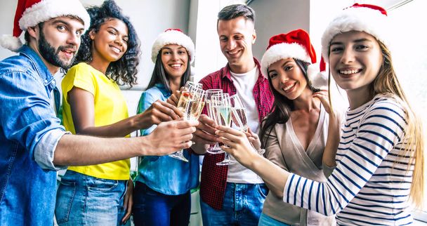 Group of happy multiracial friends celebrating together Christmas with glasses of champagne - Foto, Imagen